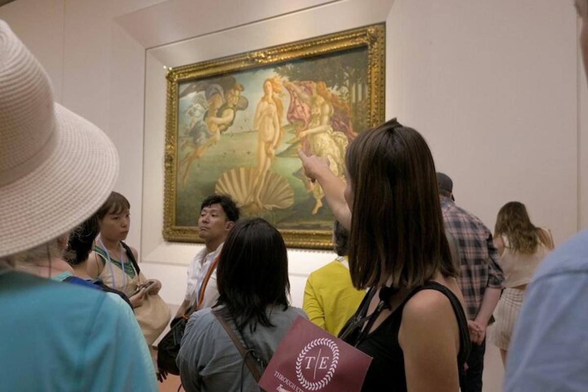 um grupo de pessoas olhando para uma pintura em um museu