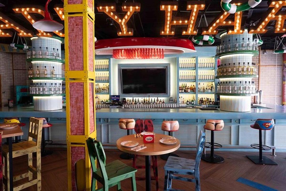 một nhà hàng có quầy bar với bàn và ghế