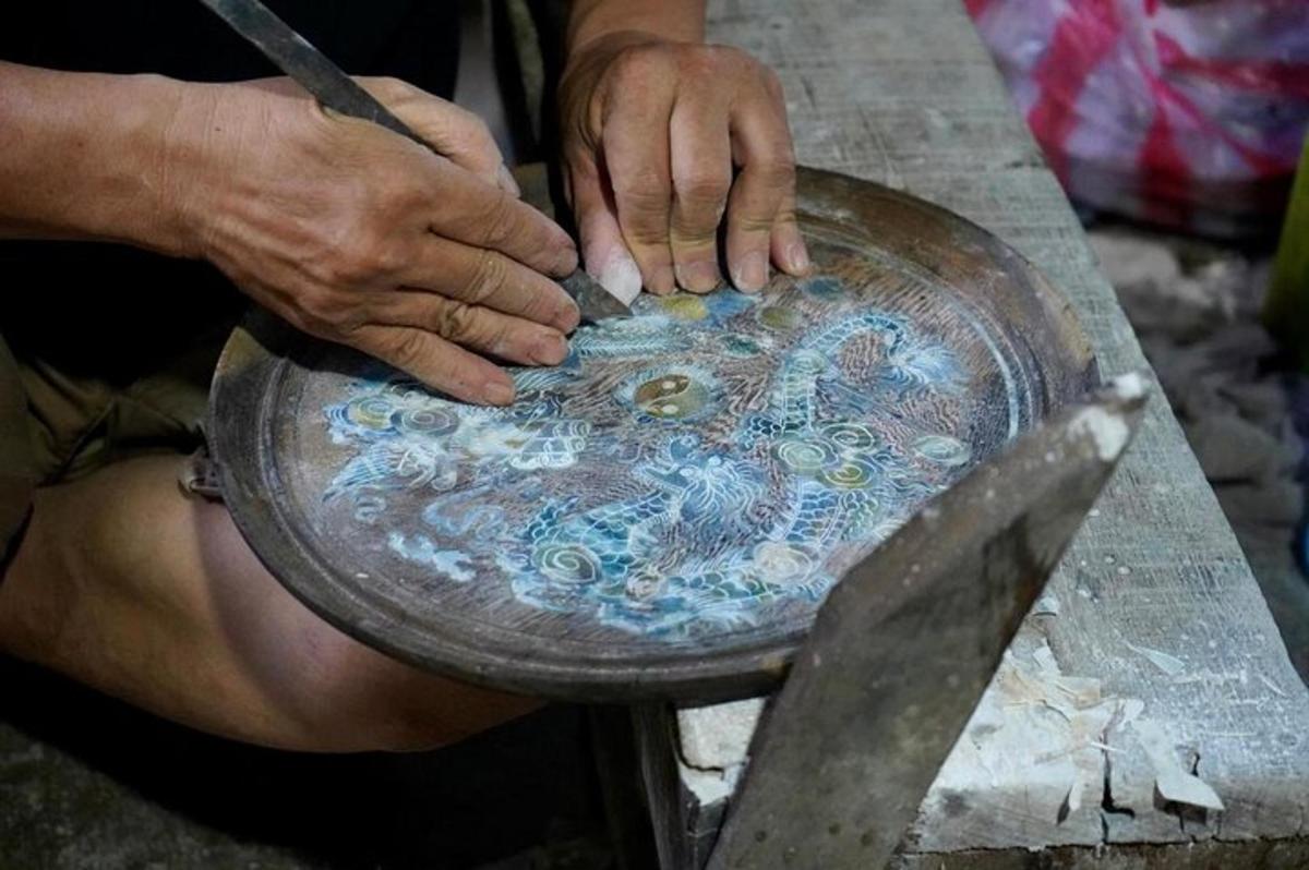 a man ispainting a plate on a table