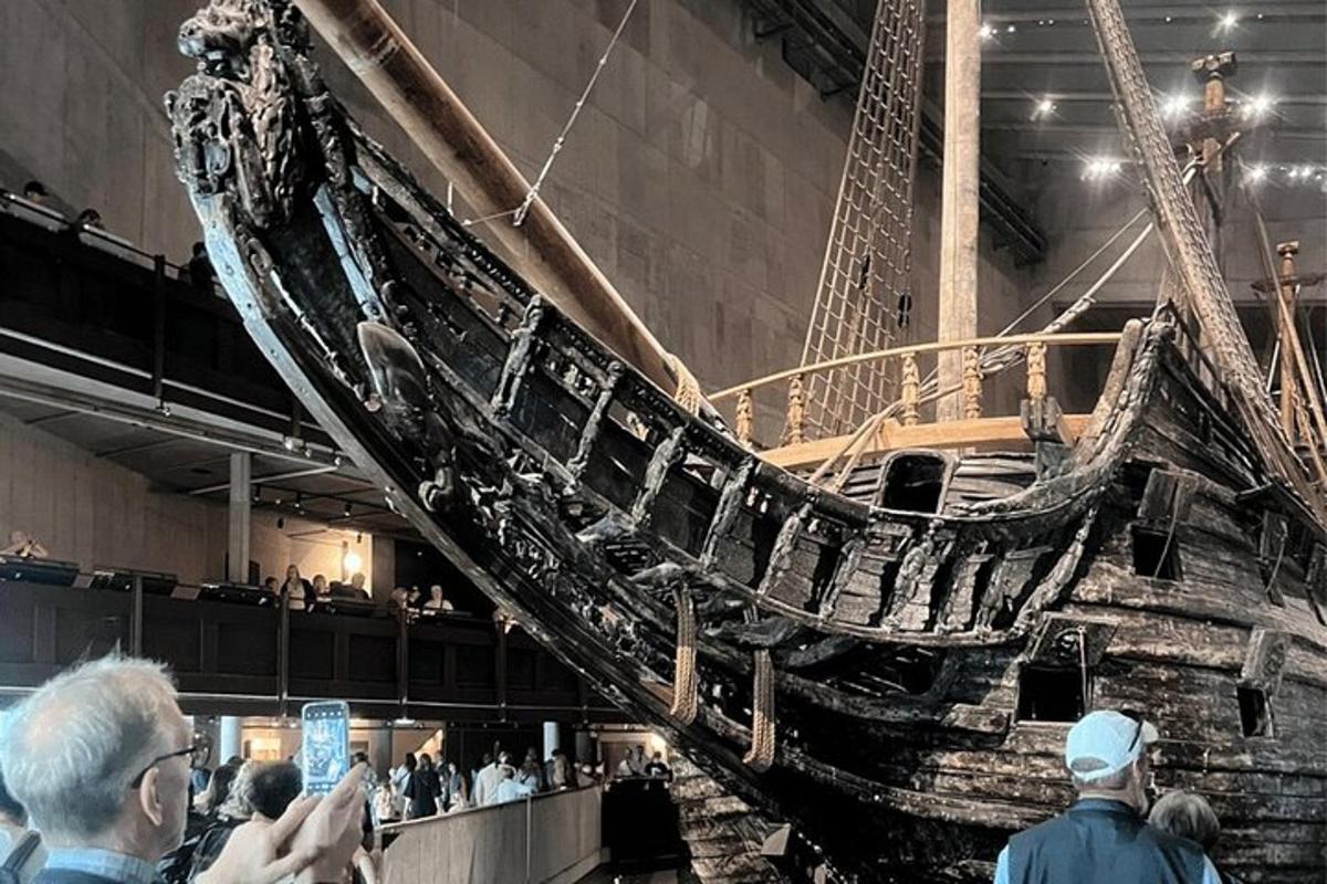 a boat in a museum with people standing around it