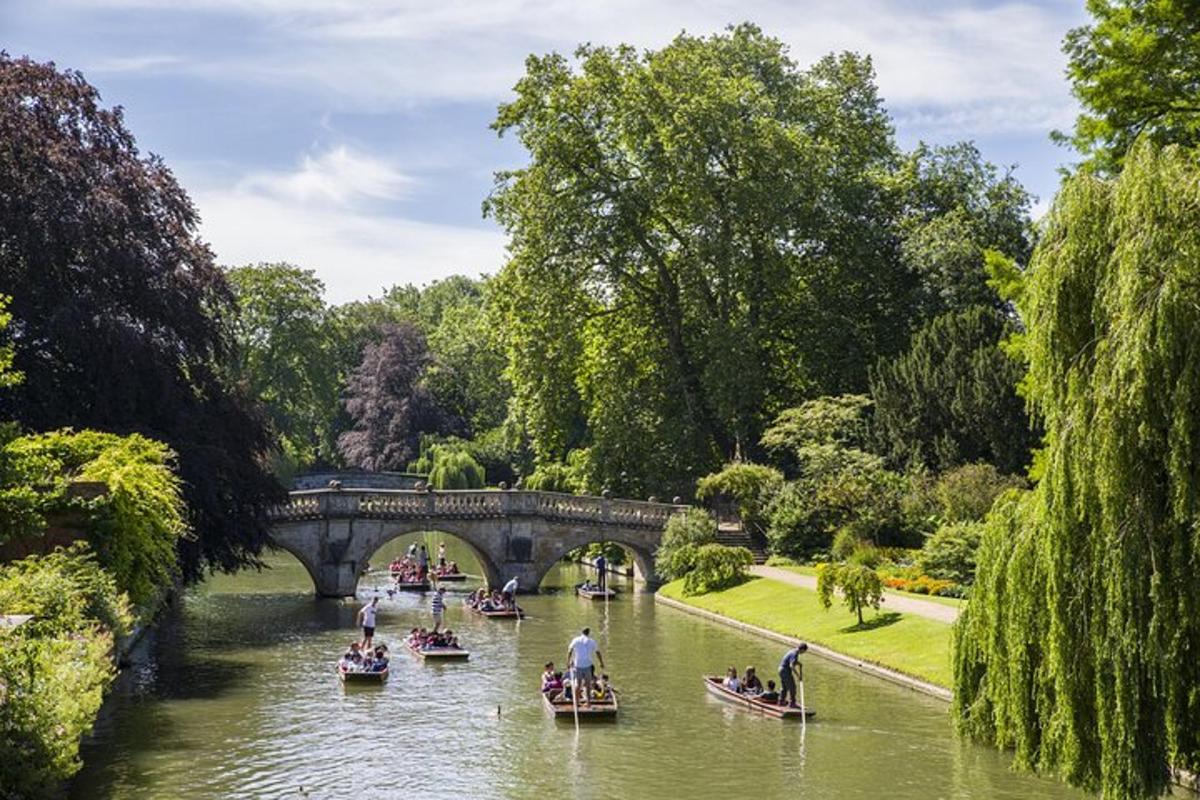 Un grupo de barcos en un río con un puente.