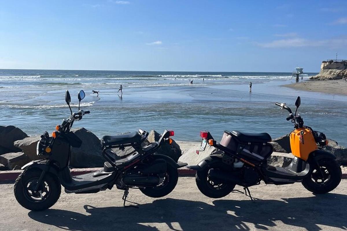 dva motocykly zaparkované na pláži u oceánu