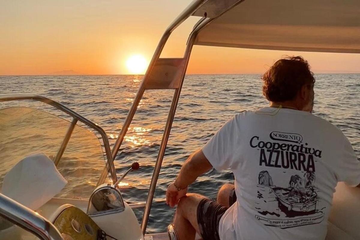 un uomo seduto su una barca che guarda il tramonto