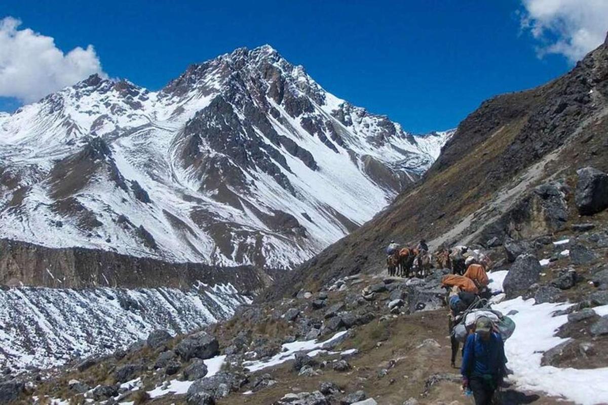 eine Gruppe von Menschen, die einen schneebedeckten Berg hinaufgehen