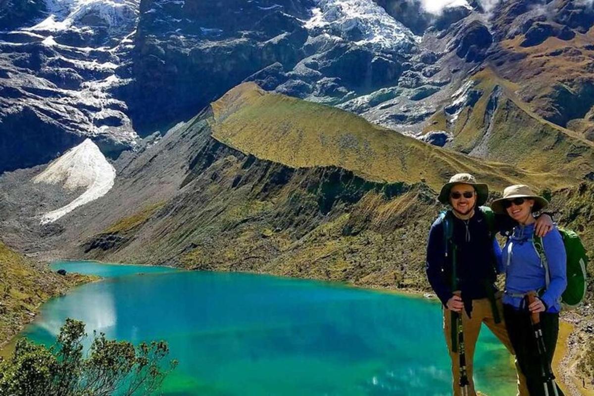 zwei Personen stehen vor einem Bergsee