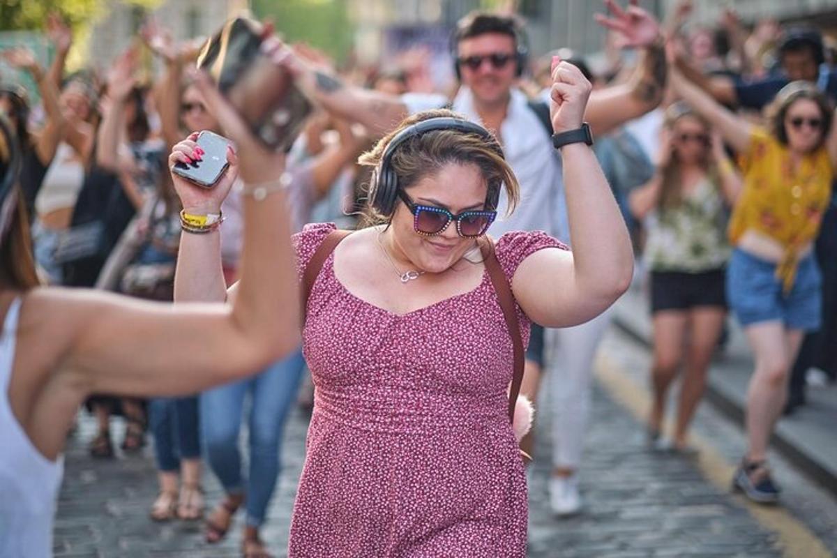 žena kráčející po ulici s davem lidí