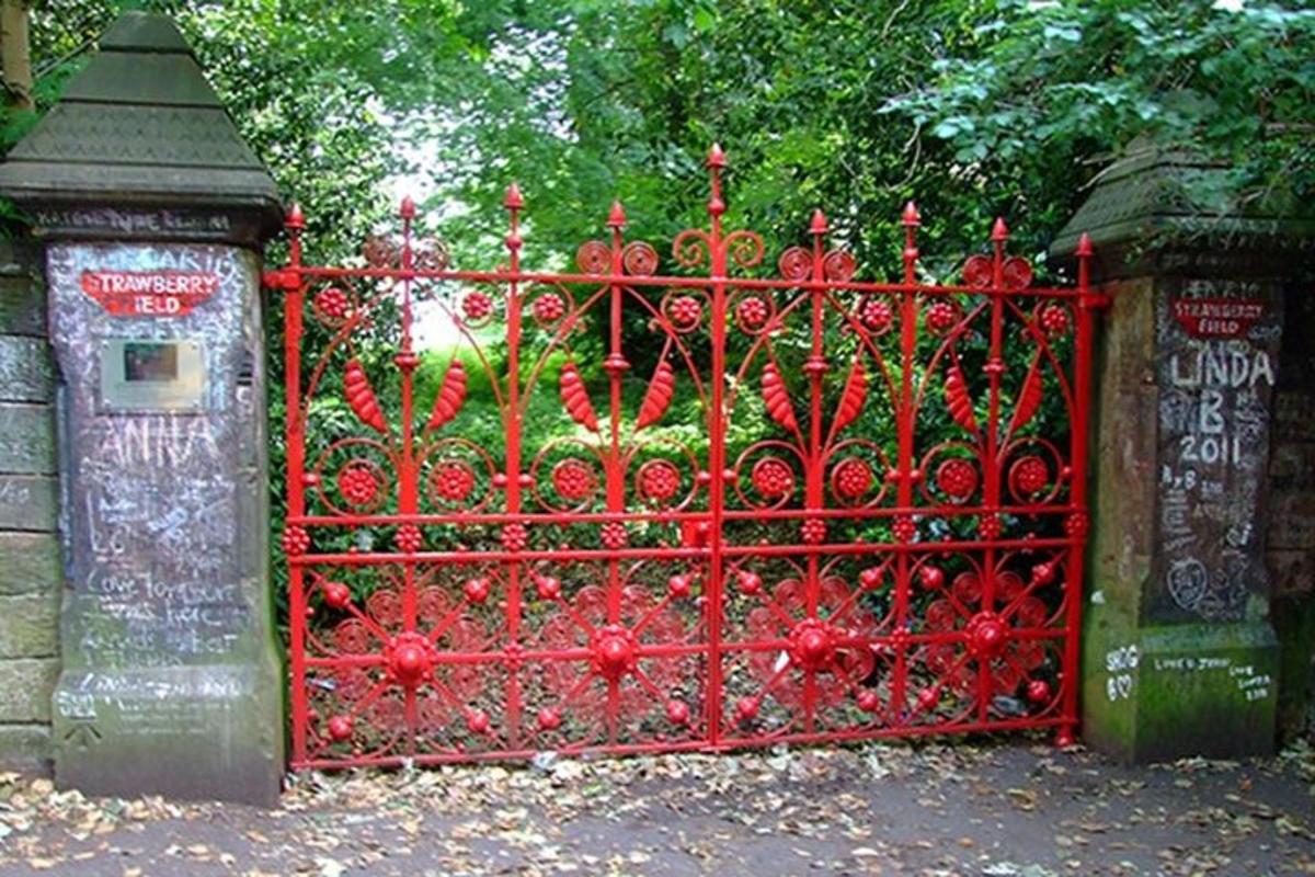 un cancello di metallo rosso davanti a un giardino