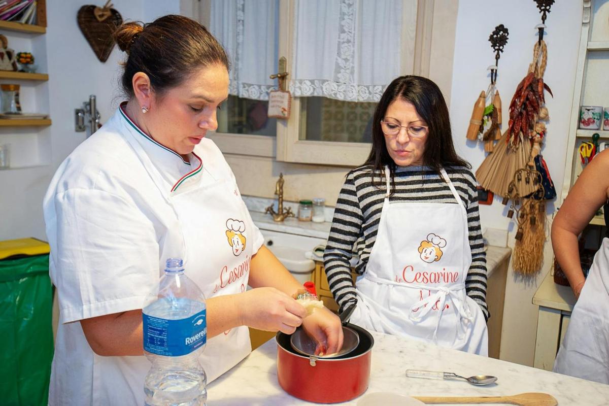 mutfakta iki kadın bir tencerede yemek hazırlıyor