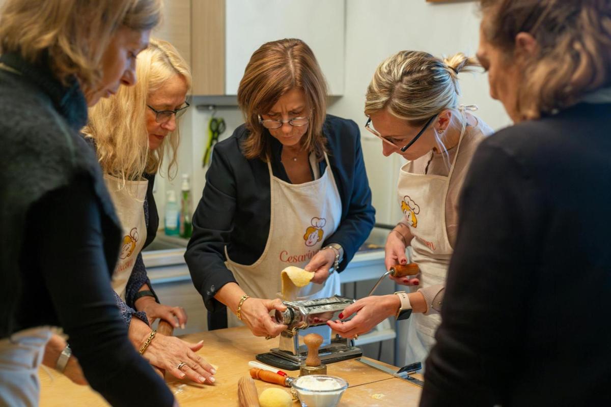 Un grupo de mujeres de pie en una cocina preparando comida.