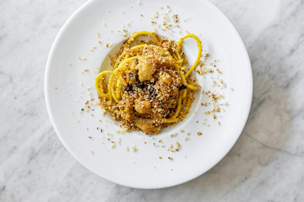 en hvit tallerken med pasta på et bord