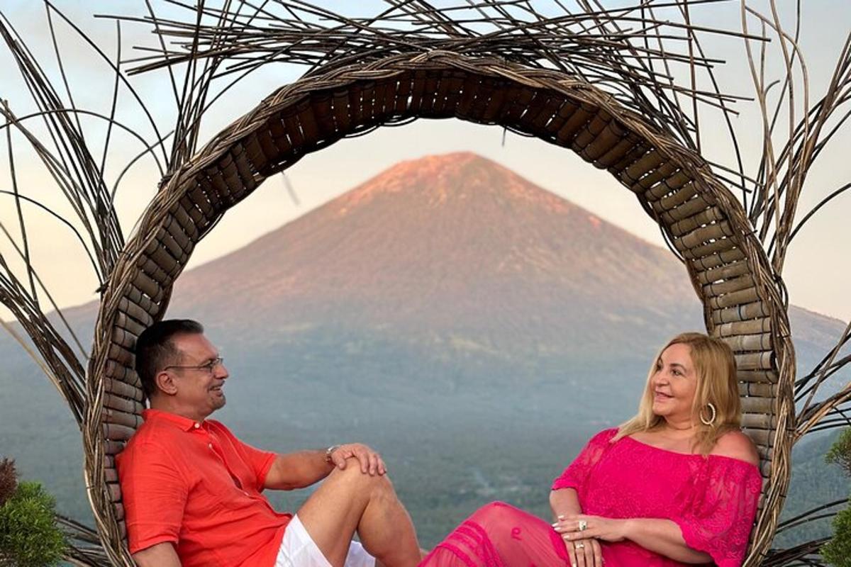 un uomo e una donna seduti in un cesto con una montagna sullo sfondo