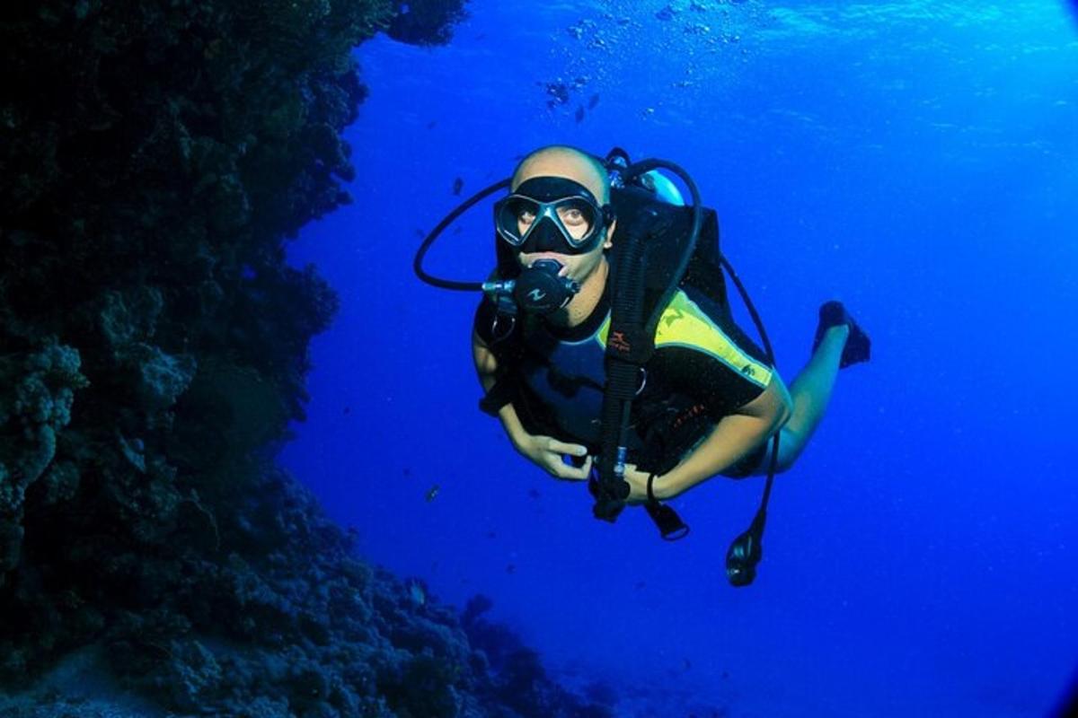 osoba v potápěčském obleku a brýlích plave v oceánu