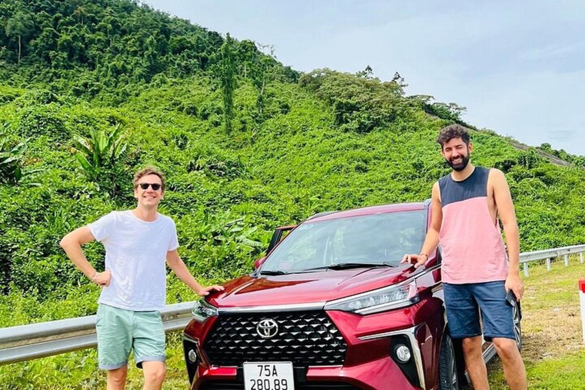 dois homens parados ao lado de um carro em uma estrada