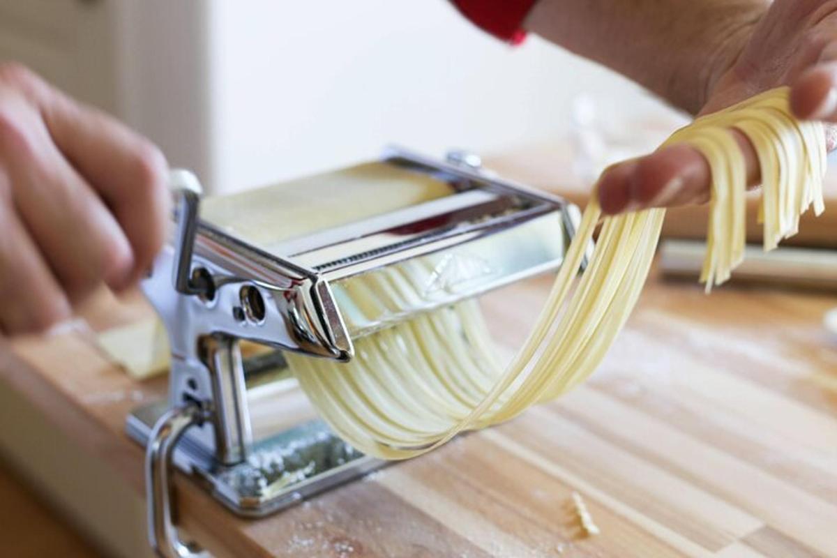 Maður er að draga pasta úr vél