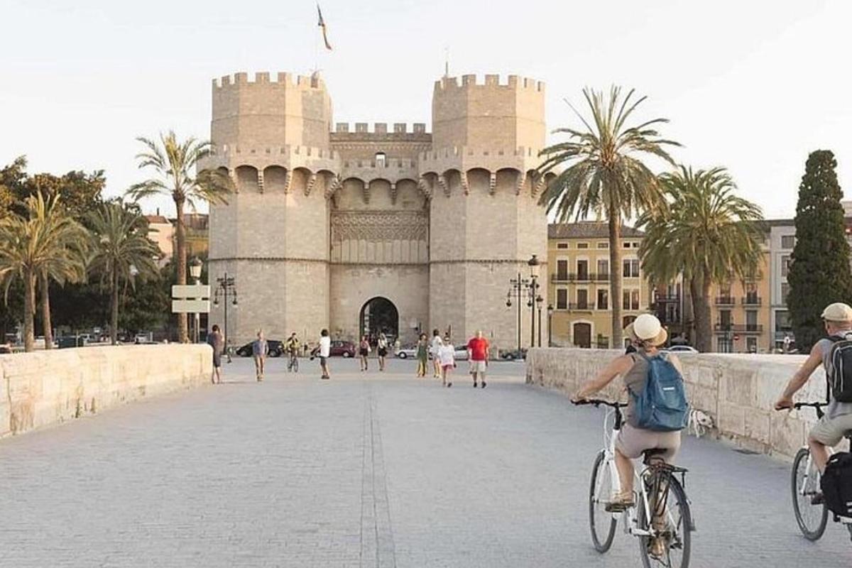 um grupo de pessoas andando de bicicleta em frente a um prédio