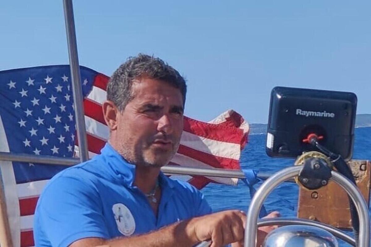 en mand sidder på en båd med et amerikansk flag