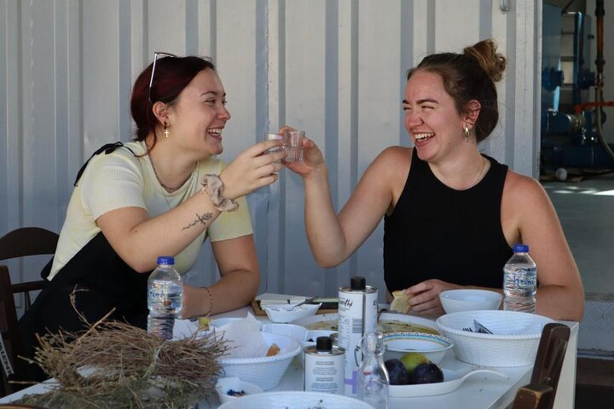 deux femmes assises à une table souriant et riant
