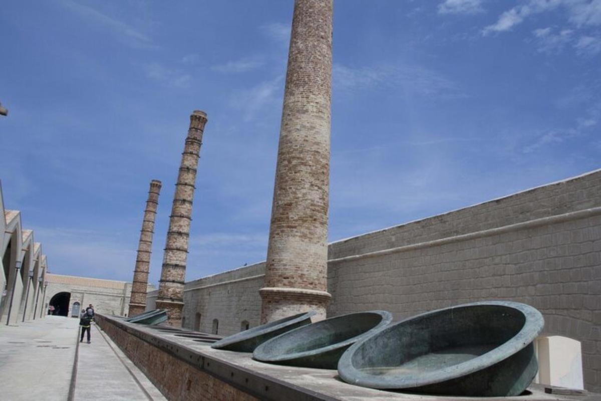 a row of toilets sitting next to a wall with two towers