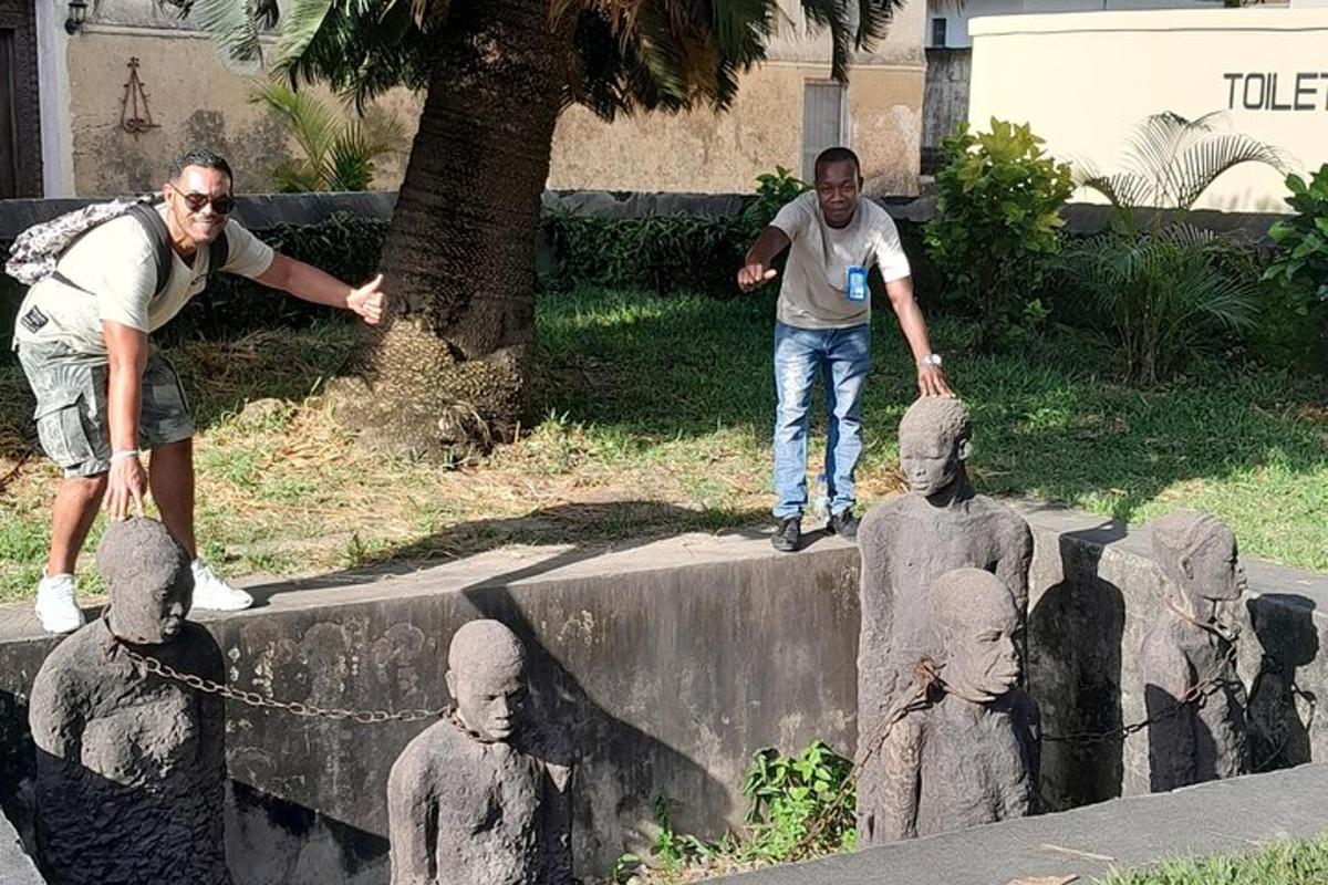 two men standing next to a statue of statues
