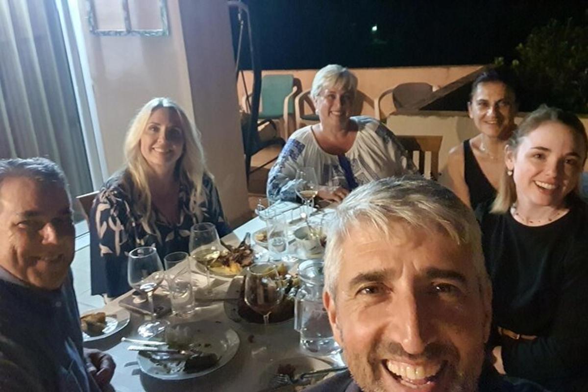 skupina ljudi, ki sedijo za večerno mizo