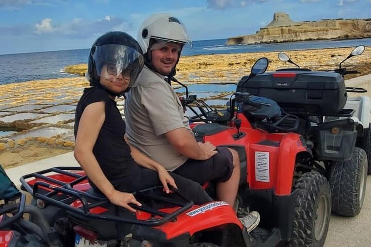 a man and a woman sitting on a quad bike