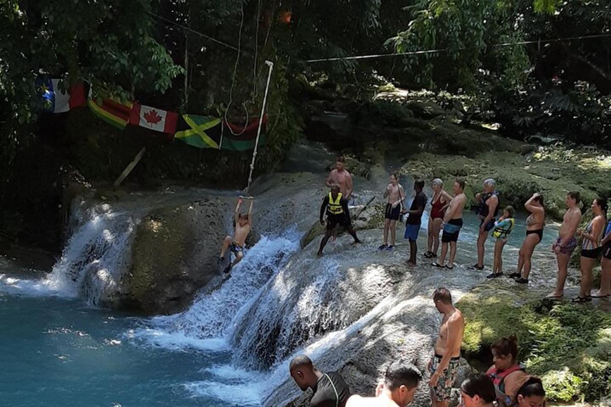 sekumpulan orang berdiri di sekeliling air terjun