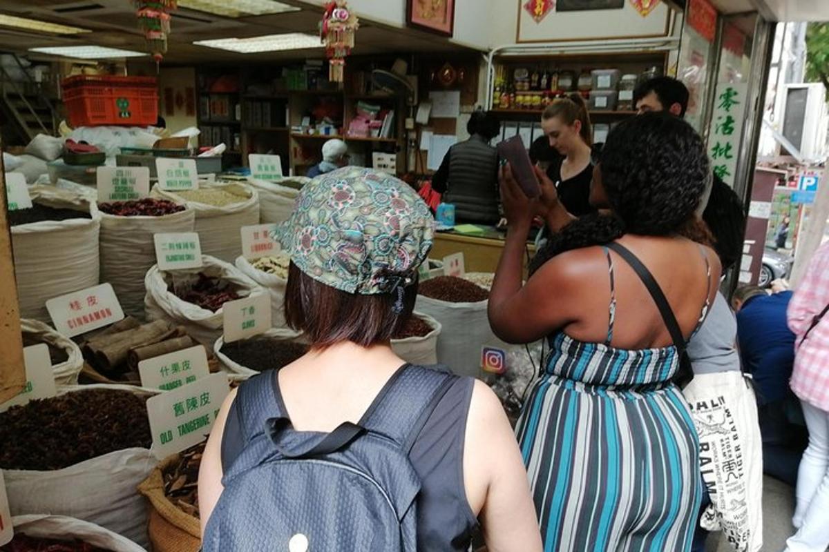 duas mulheres em pé em um mercado vendendo comida