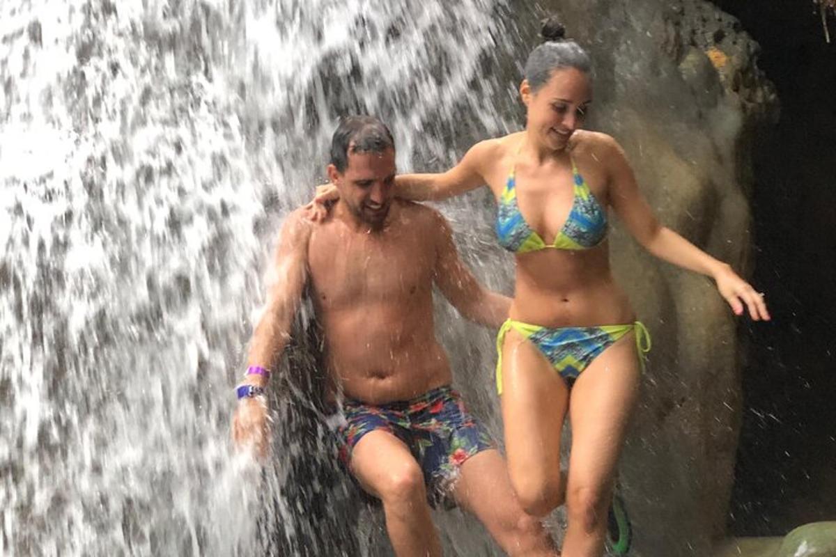 Un hombre y una mujer en traje de baño en una cascada