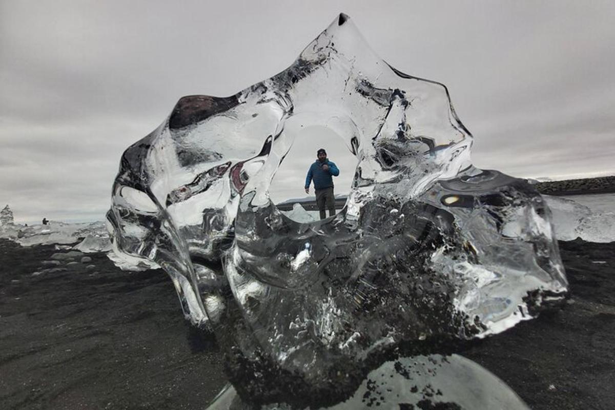 un uomo è in piedi accanto a una scultura di ghiaccio