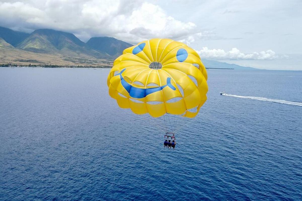 payung terjun kuning dan biru terbang di atas air