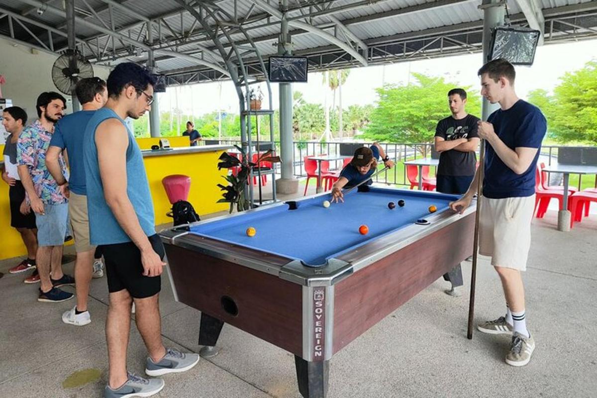 sekumpulan lelaki berdiri mengelilingi meja pool