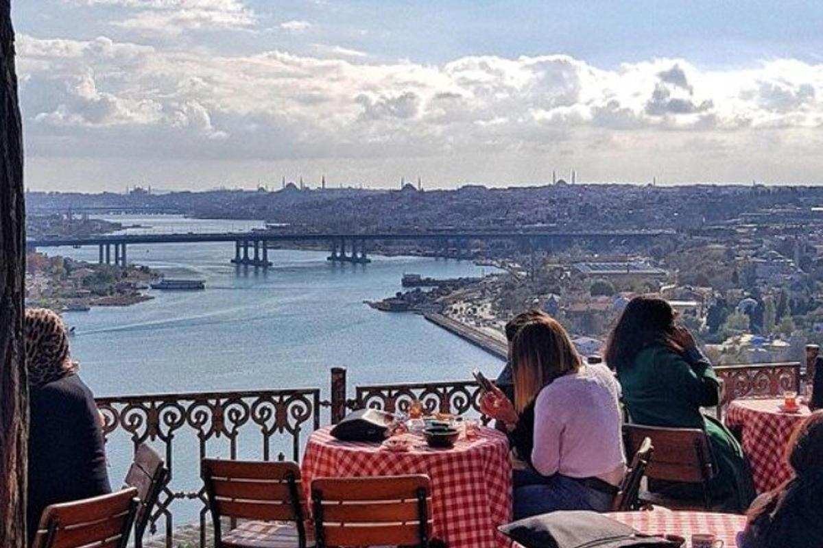 nehre bakan masalarda oturan bir grup insan