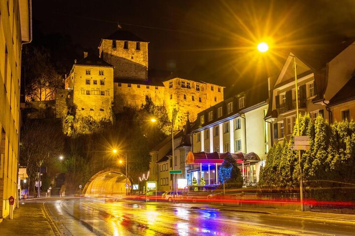 eine Stadtstraße bei Nacht mit einem Schloss