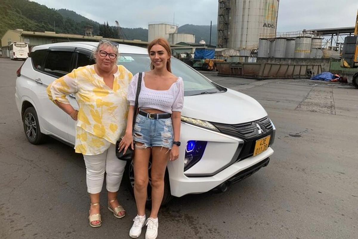 muž a žena stojící před autem
