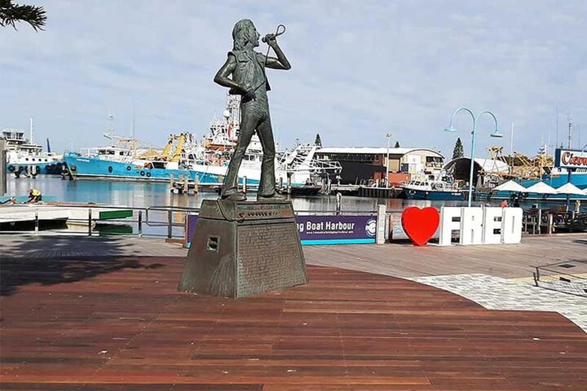 una estàtua d'un home tocant una trompeta en un port esportiu