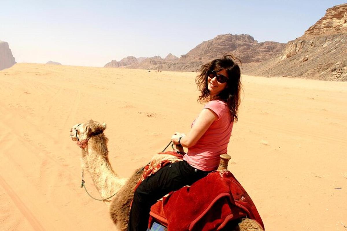 una donna che cavalca un cammello nel deserto