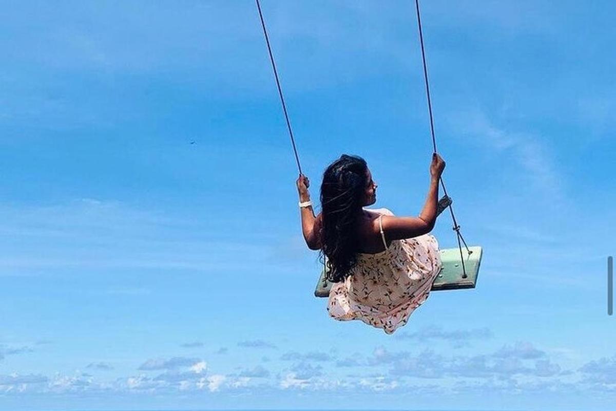 a woman in a dress is on a swing