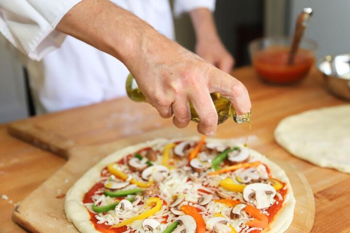 seseorang sedang membuat pizza di atas meja