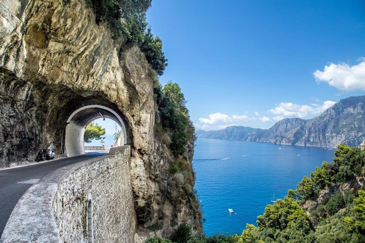 a road on the side of a mountain next to the water