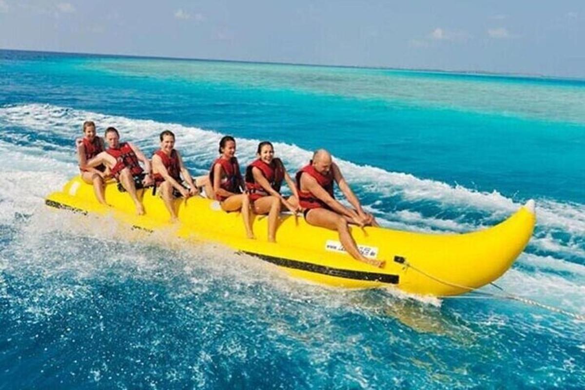 eine Gruppe von Menschen, die auf einem Bananenboot im Meer fahren