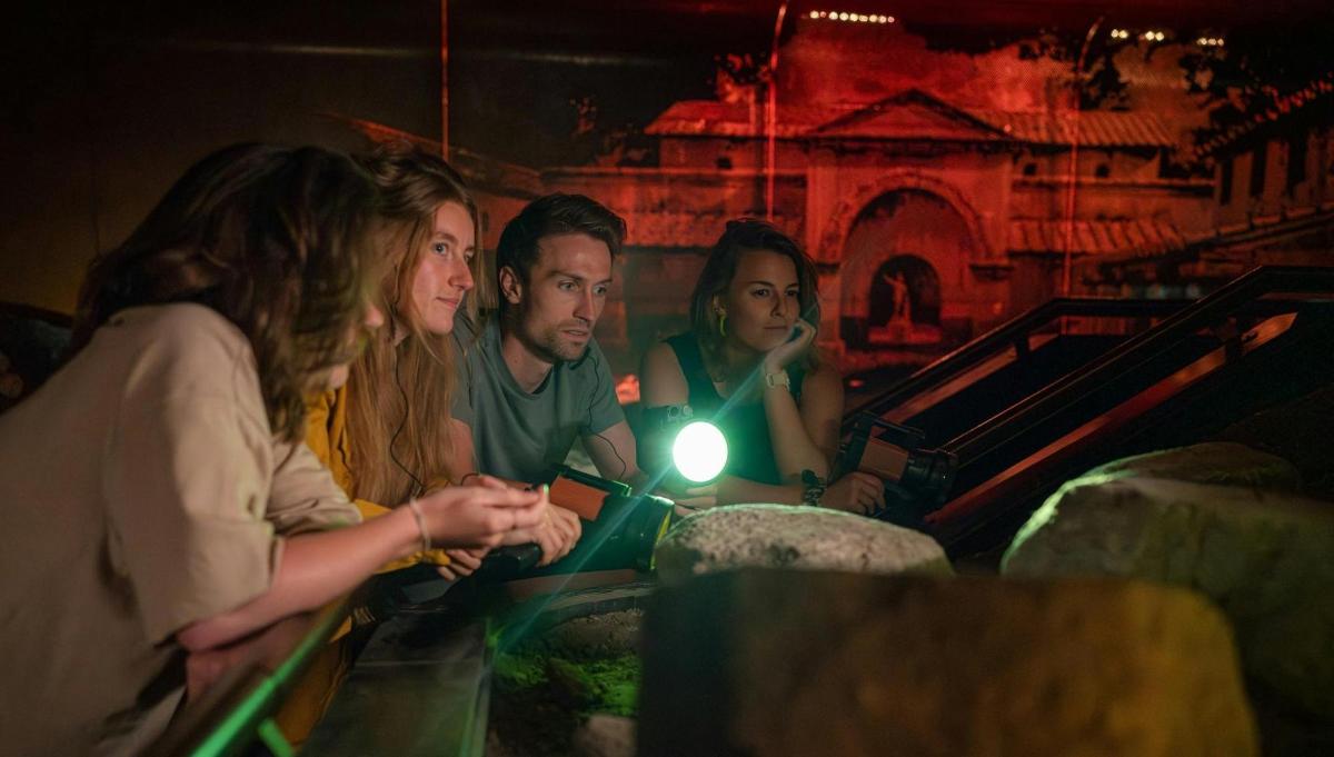 a group of people sitting around a table with a light