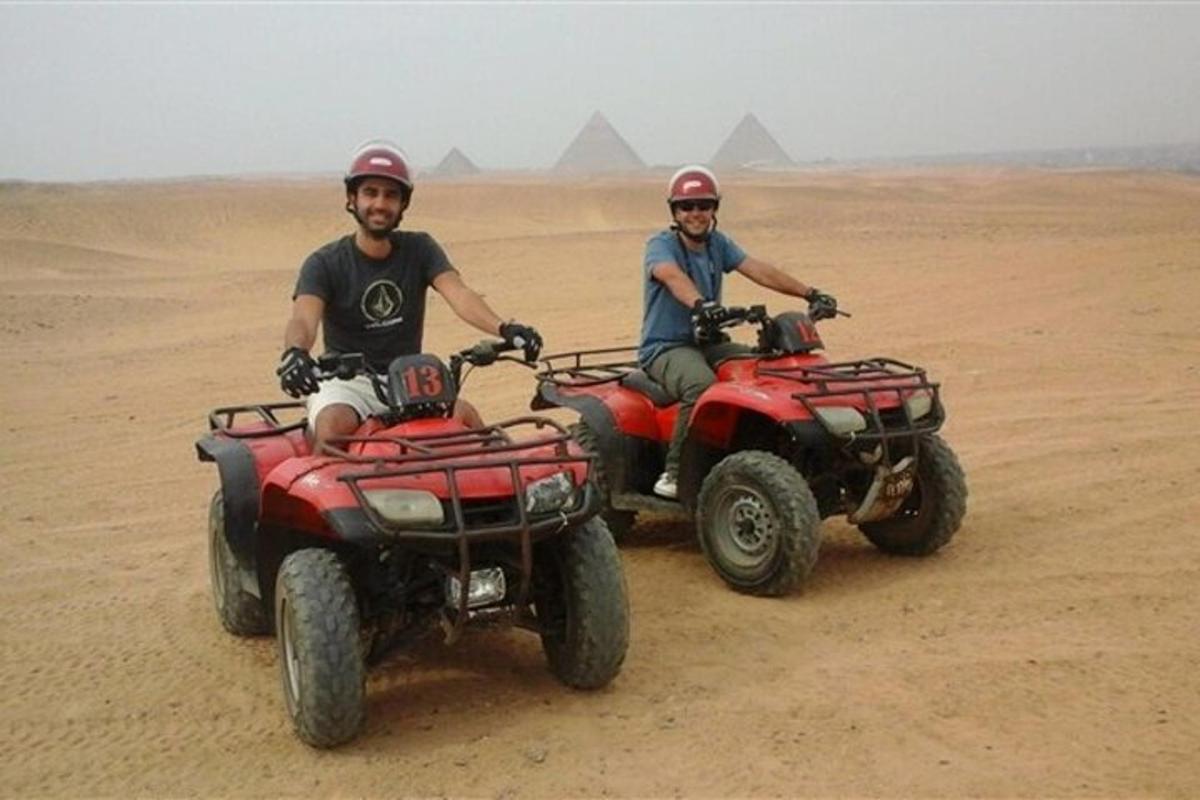 due uomini guidano quad nel deserto