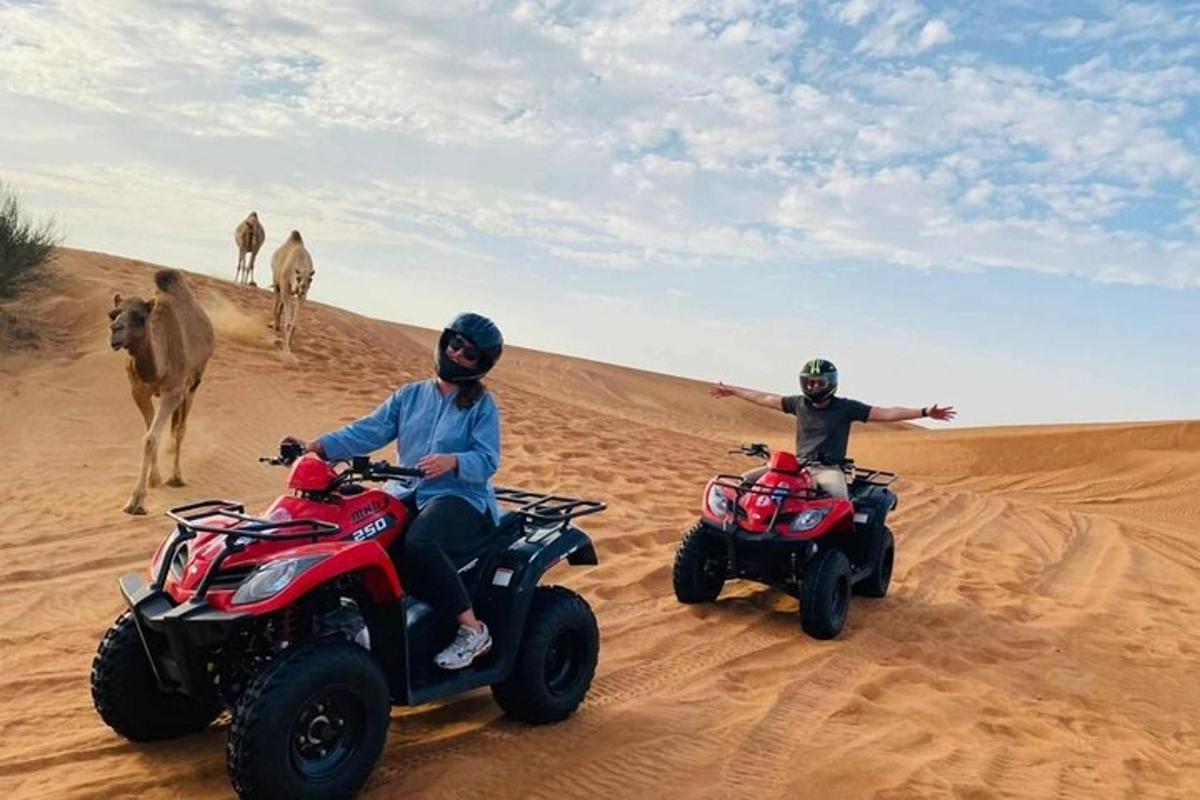 due persone che guidano quad nel deserto con un cammello