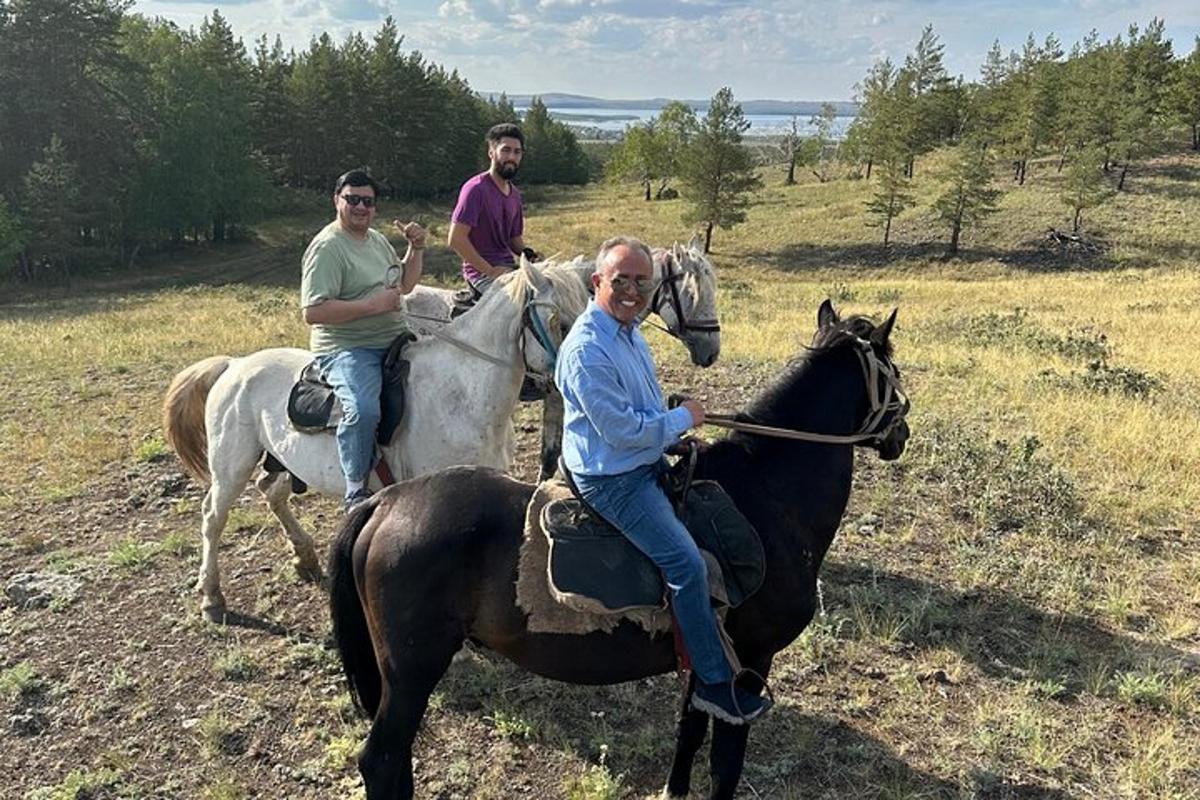 three men riding on horses in a field