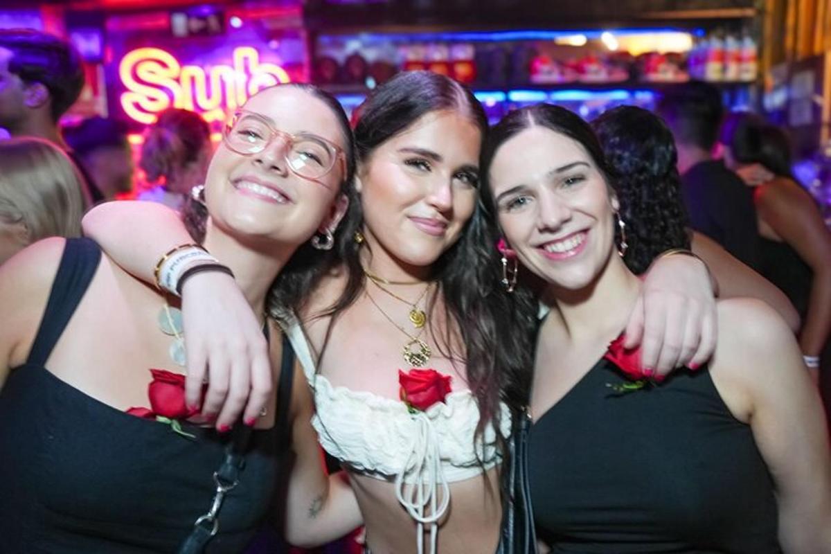 três mulheres posando para uma foto em uma festa