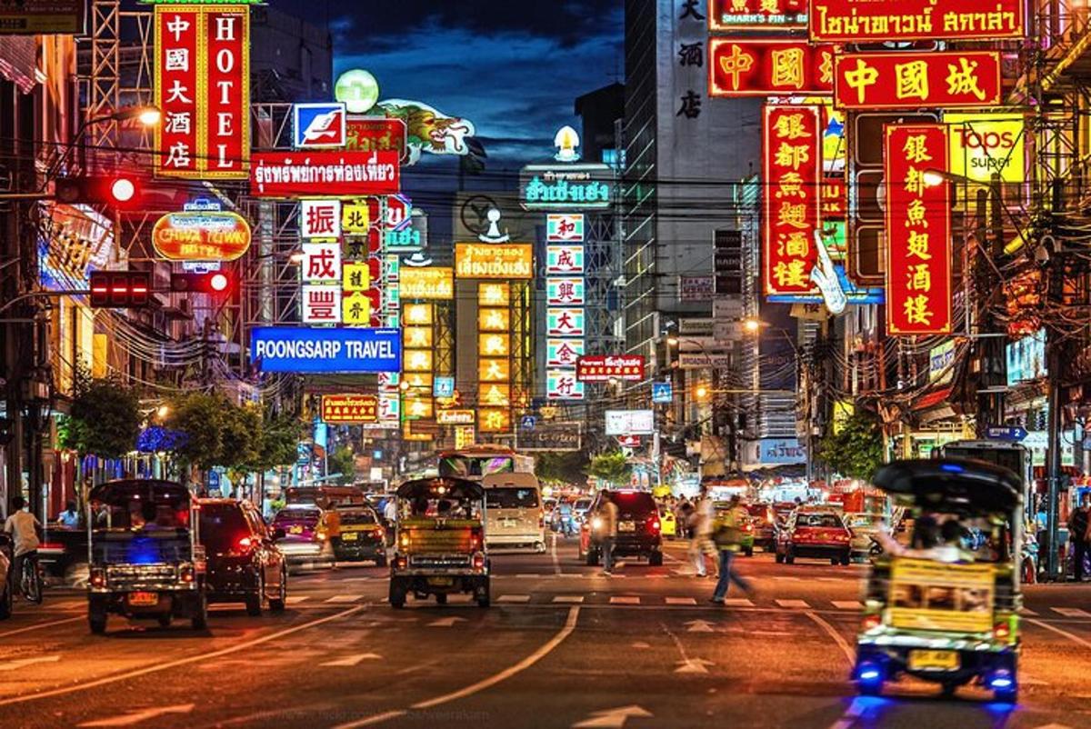 Una calle concurrida de la ciudad por la noche con letreros de neón.