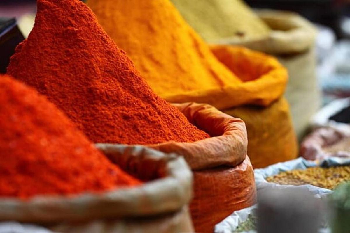 a pile of different colored spices in a basket