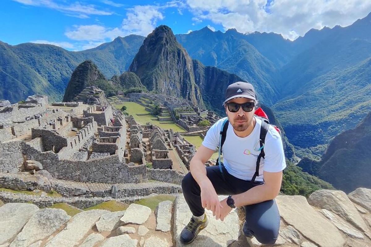 muž sedící na okraji pyramidy u ruin