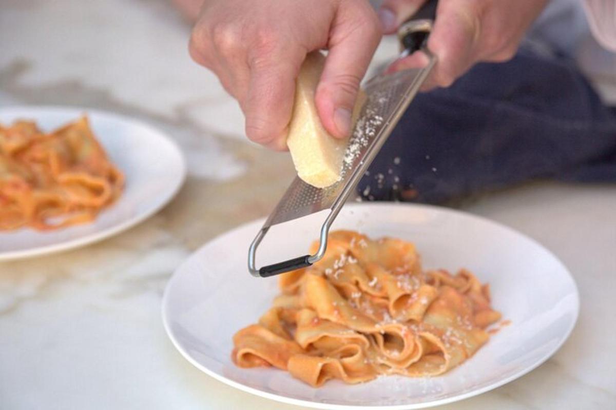 uma pessoa está comendo macarrão com garfo e faca