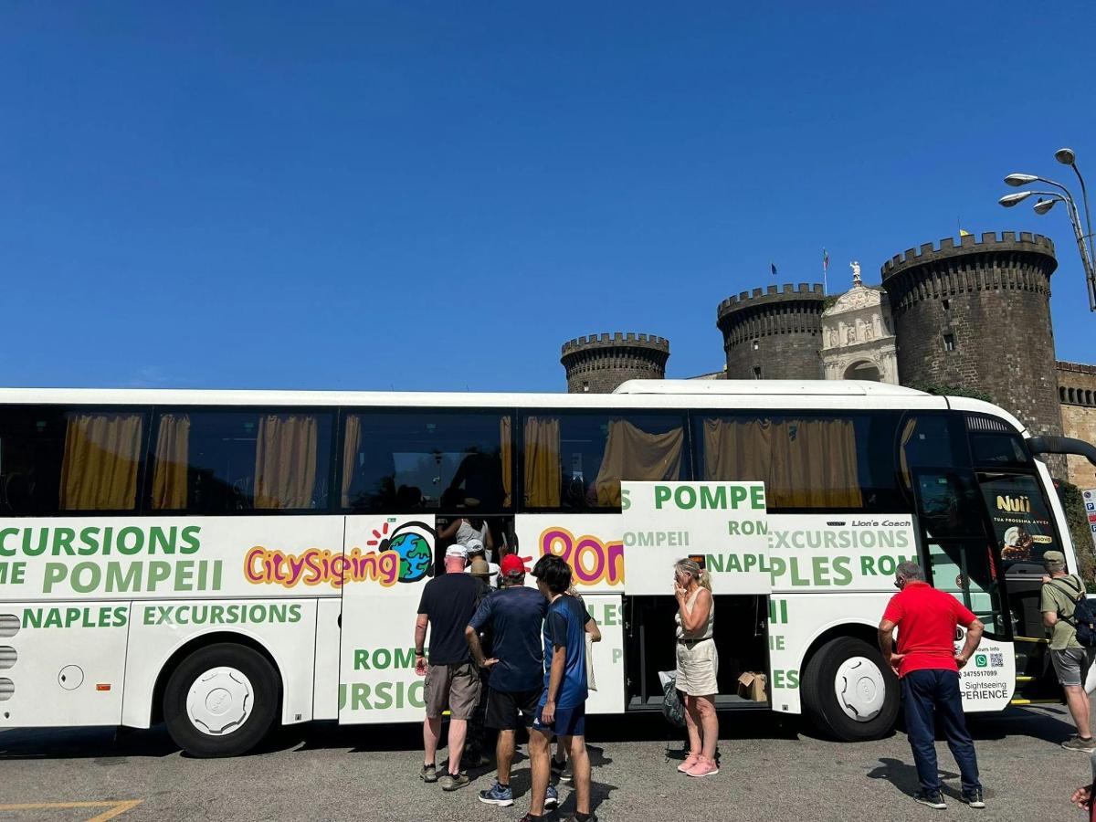un grup de oameni care stau în fața unui autobuz